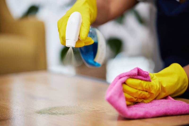 Spraying and wiping a wooden table